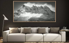 Framed black and white mountain landscape above a modern sofa in a living room. Dents Du midi print