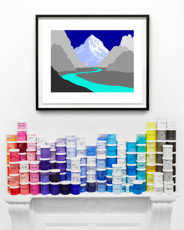 blue framed mountain print above paint cans on a mantel piece