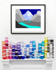 blue framed mountain print above paint cans on a mantel piece