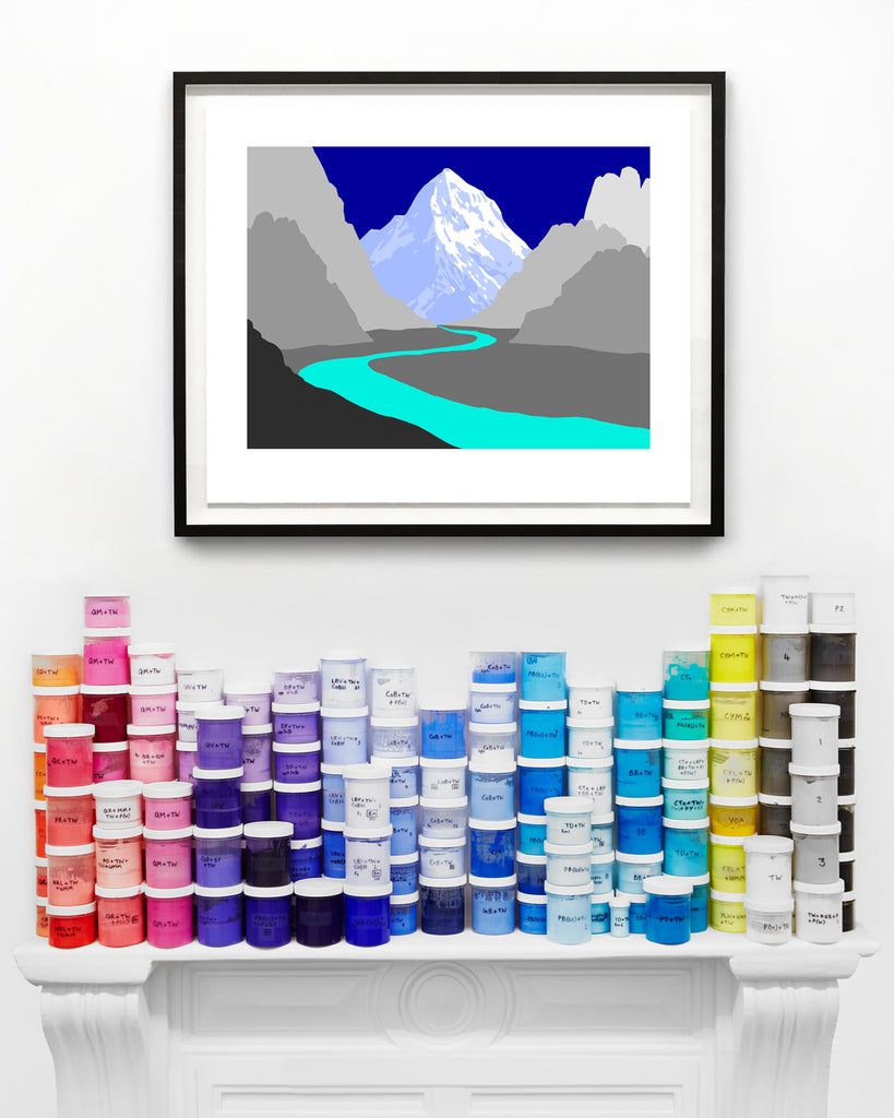 blue framed mountain print above paint cans on a mantel piece