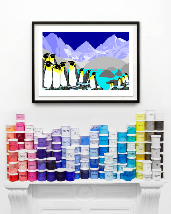 Framed penguin artwork above a shelf with colourful jars of paint.