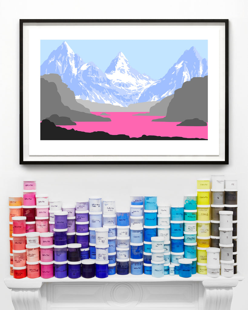 pop artwork with pale blue mountains and pink lake on wall above paint cans on a mantel piece.