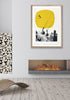 yellow ski wall art with ski jumper framed on a wall above a fireplace. 
