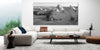 large print of Dent D'Oche above a sofa in a white room