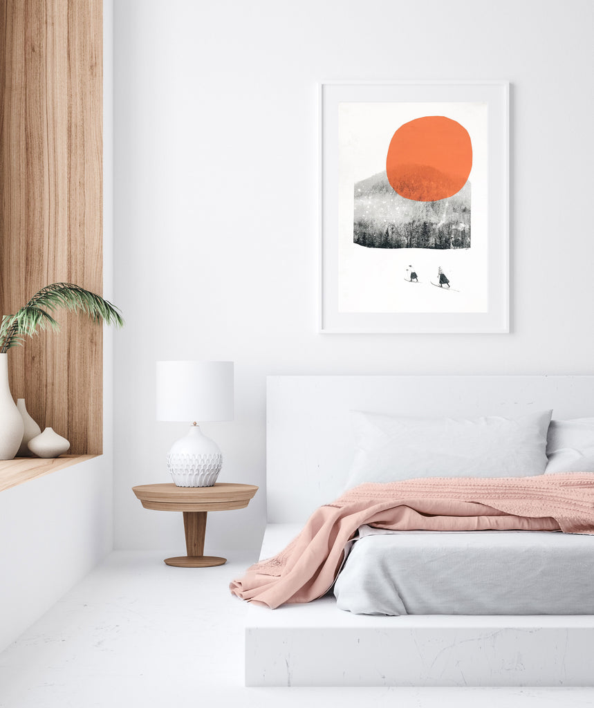 orange retro ski art print framed in a wall in a white bedroom