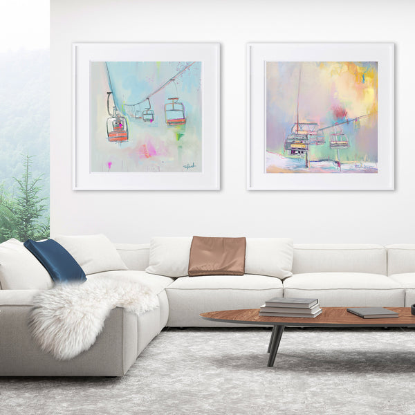 2 painted ski prints framed on a wall over a white sofa in a chalet living room 
